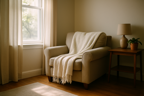 alt_text: A serene living room corner with morning light, an armchair, and a cozy throw blanket.