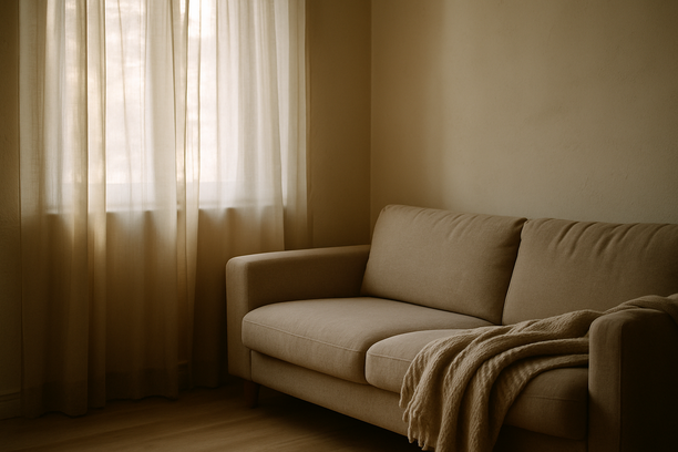 alt_text: A serene living room corner with soft light, a cozy sofa, and a peaceful, calming atmosphere.