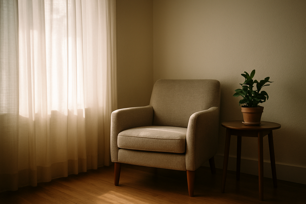 alt_text: A serene living room corner with an armchair and plant, bathed in gentle morning light.