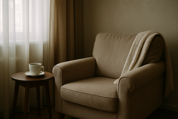 alt_text: A tranquil living room corner with a cozy armchair and an untouched cup of tea on a table.